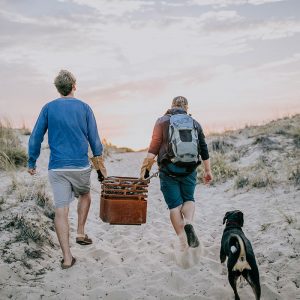 2 kompisar bär Höfats Cube Eldkorg & Kolgrill rost till stranden