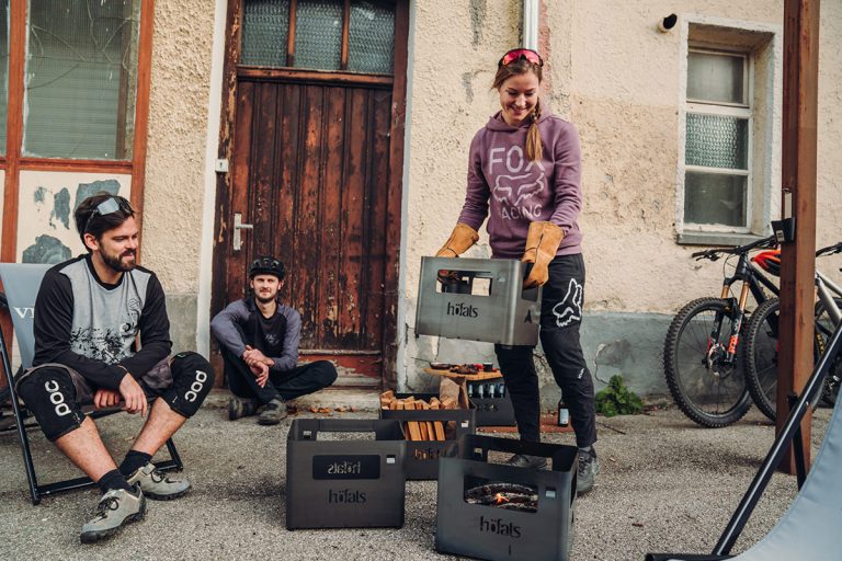 Kvinna bär Höfats Beer Box Eldkorg fylld med aska