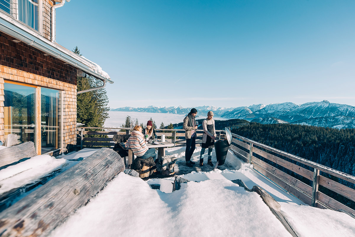 Vänner njuter av vintergrillning på Höfats Cone Kolgrill tillsammans