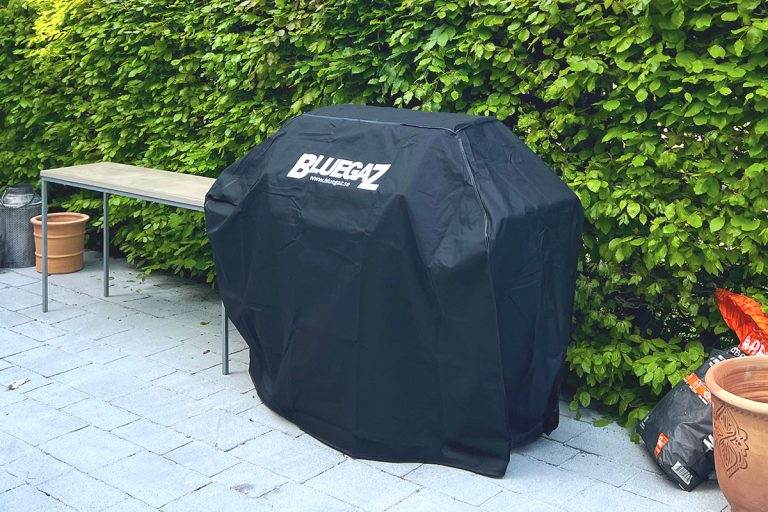 Bluegaz X1 Gasolgrill med grillöverdrag framför häck