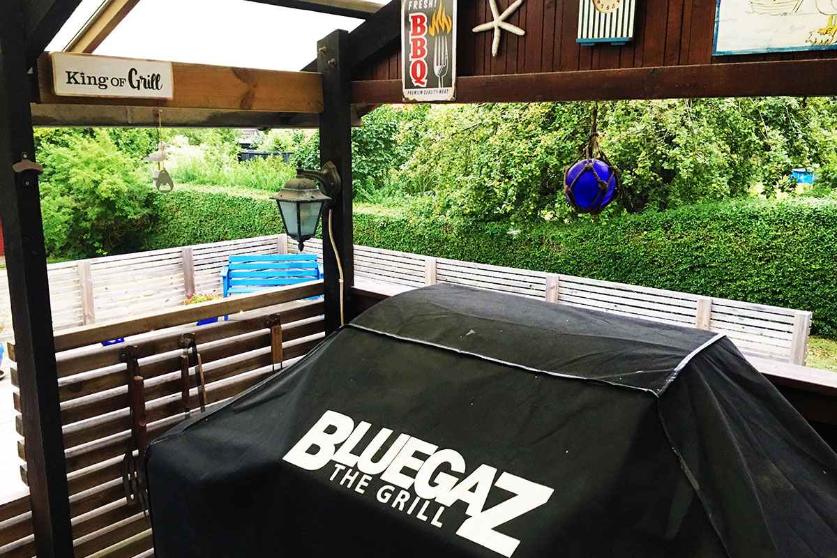 Bluegaz Z1 Gasolgrill täckt med grillöverdrag står på terrass