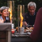 Höfats Spin Eldlykta 90 grå brinner på matbord framför äldre par