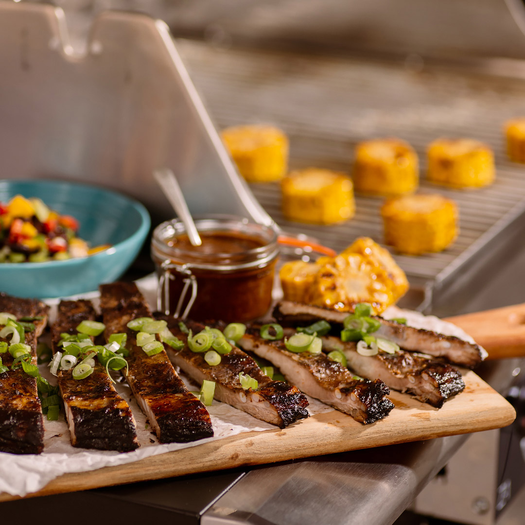 Servering av Jamaican Jerk-marinerade revben med mango- och bönsalsa