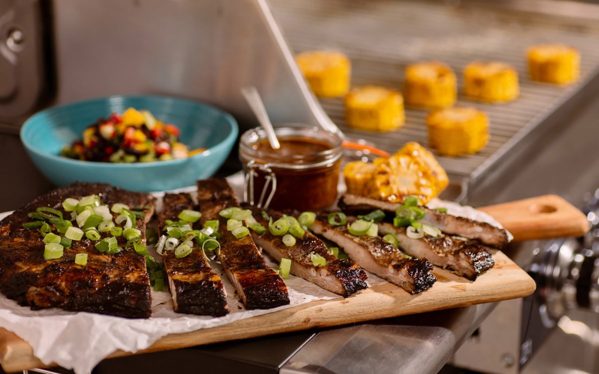 Servering av Jamaican Jerk-marinerade revben med mango- och bönsalsa