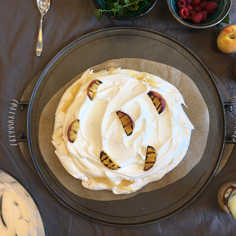 Vegansk pavlova med grillade persikor på ett bord