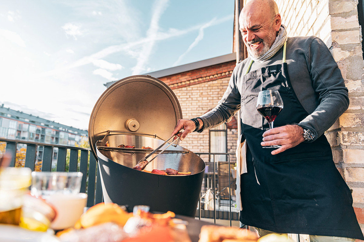 Man grillar på Bowl Eldskål på balkong