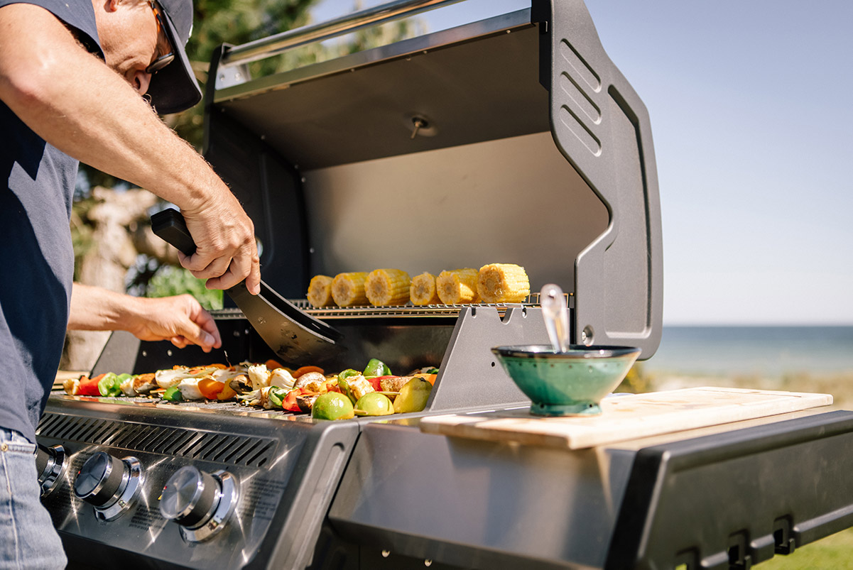 Man grillar på en Bluegaz X1 Gasolgrill med havet i bakgrunden