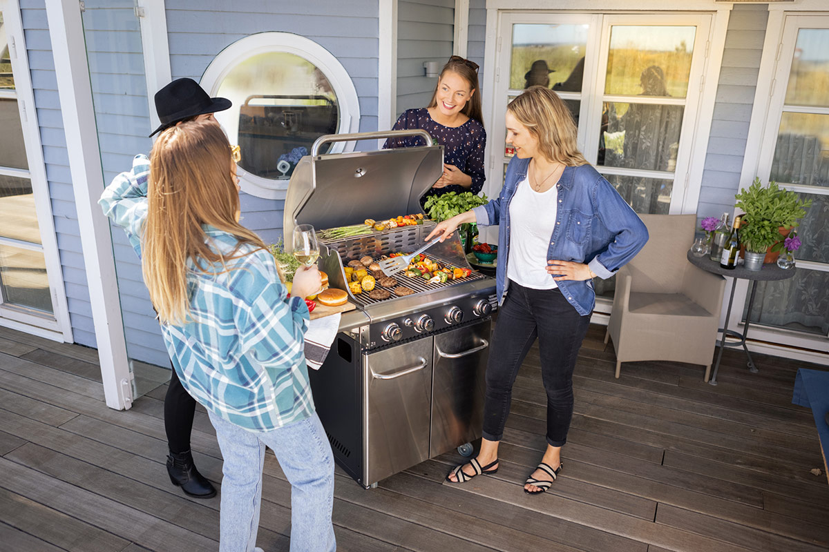 4 tjejer grillar hamburgare och grillspett på Bluegaz Z1 Gasolgrill på terrass