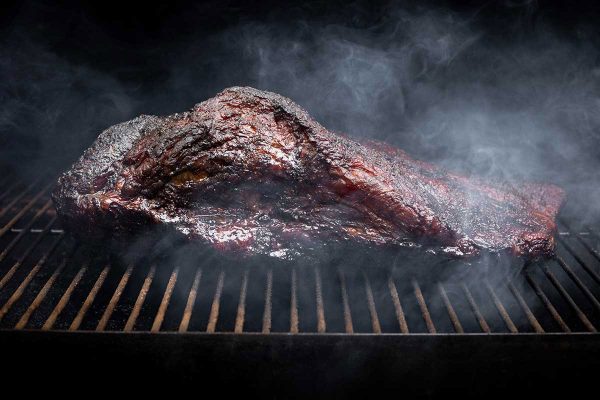 En bit kött som håller på att rökas på en grill