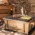 ProQ Flatdog Bärbar grill utomhus på träbord med kött och sparris