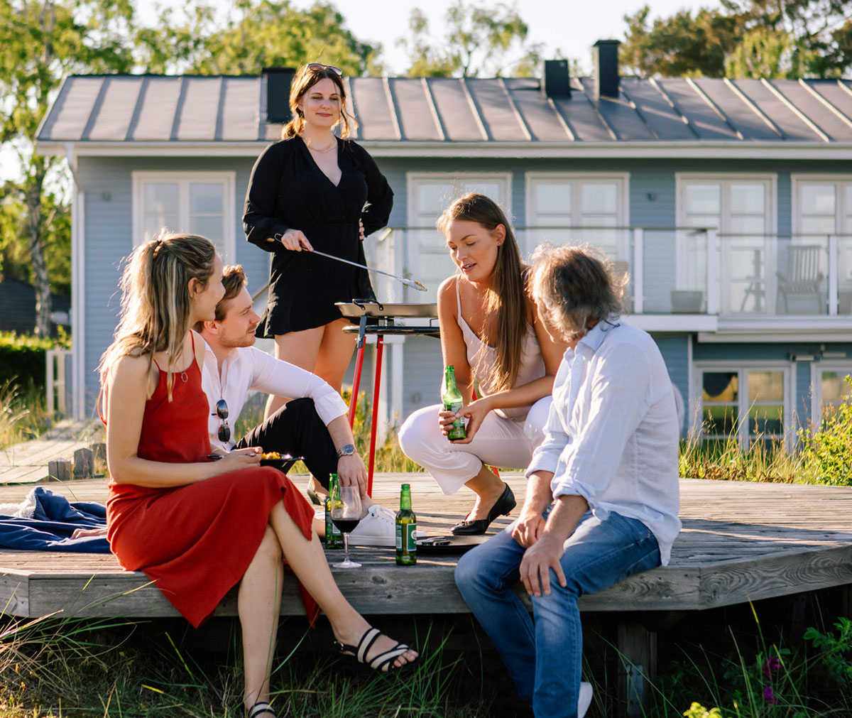 Sällskap grillar paella på Vaello Paellaset 46 cm på terrass med hus i bakgrunden