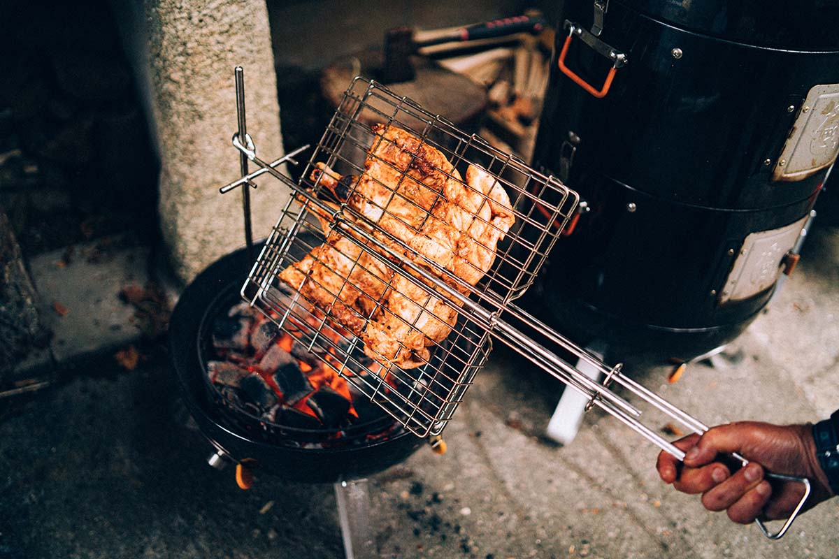 Man håller i ProQ Flip'n Grate grillhalster med kyckling inuti