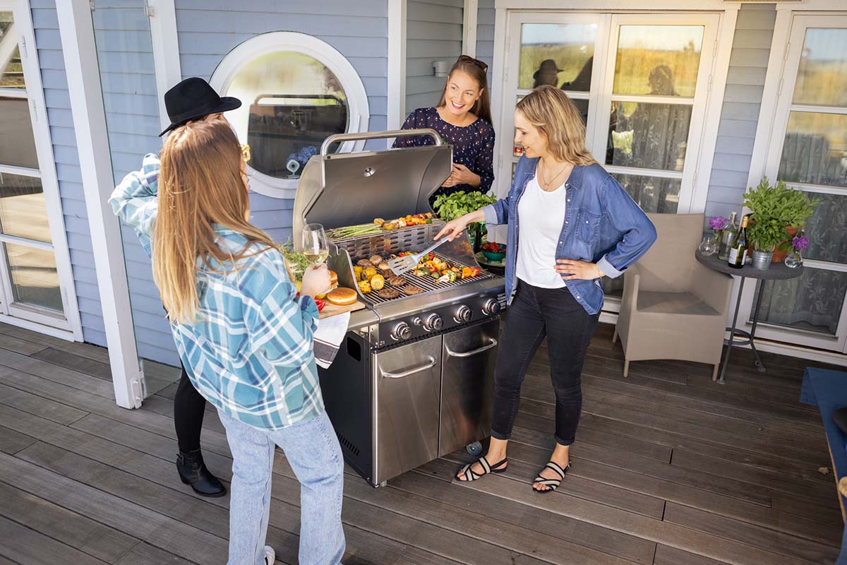 4 tjejer grillar hamburgare och grillspett på Bluegaz Z1 Gasolgrill på terrass