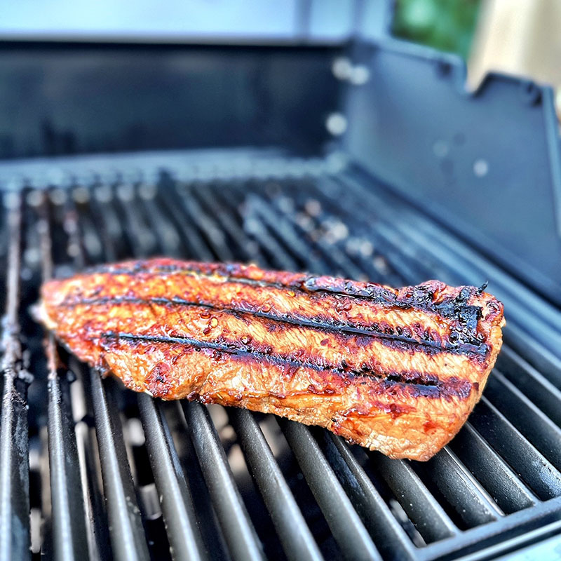 Färdiggrillad fläskytterfilé vilar på grillgaller