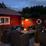 Bluegaz Teide Terrassvärmare brinner på uteplats under kvällstid framför soffgrupp