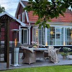 Bluegaz Teide Terrassvärmare på trädäck framför röd villa med gren i förgrunden