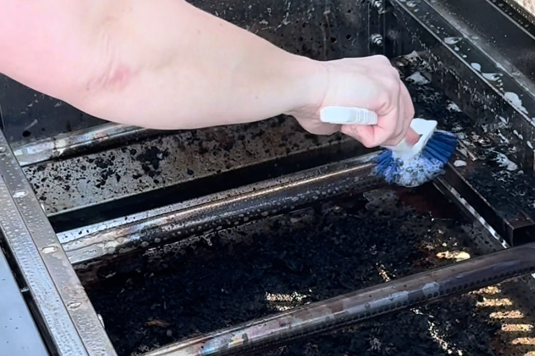 Rengör brännare på gasolgrill med diskborste och såpa