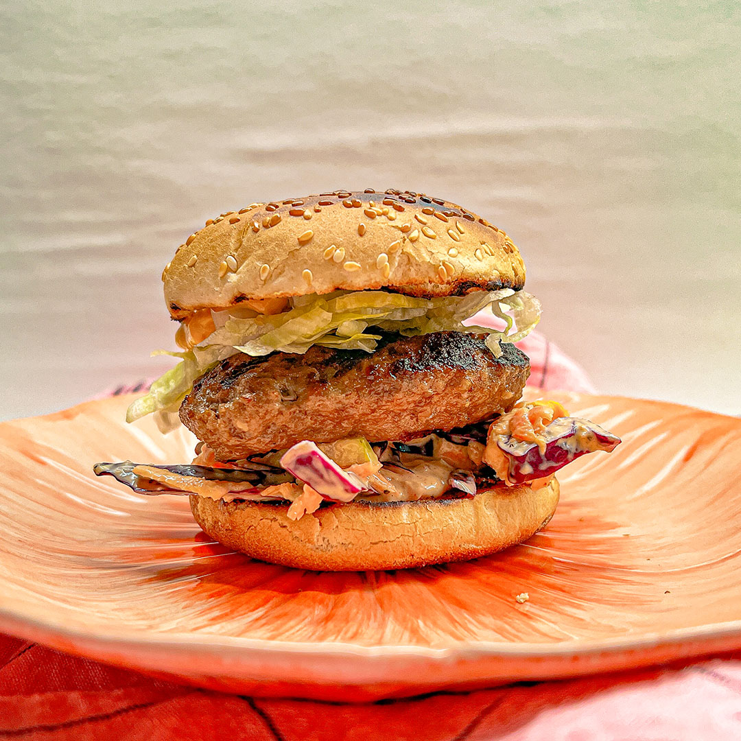 Grillad hamburgare med coleslaw på orange tallrik