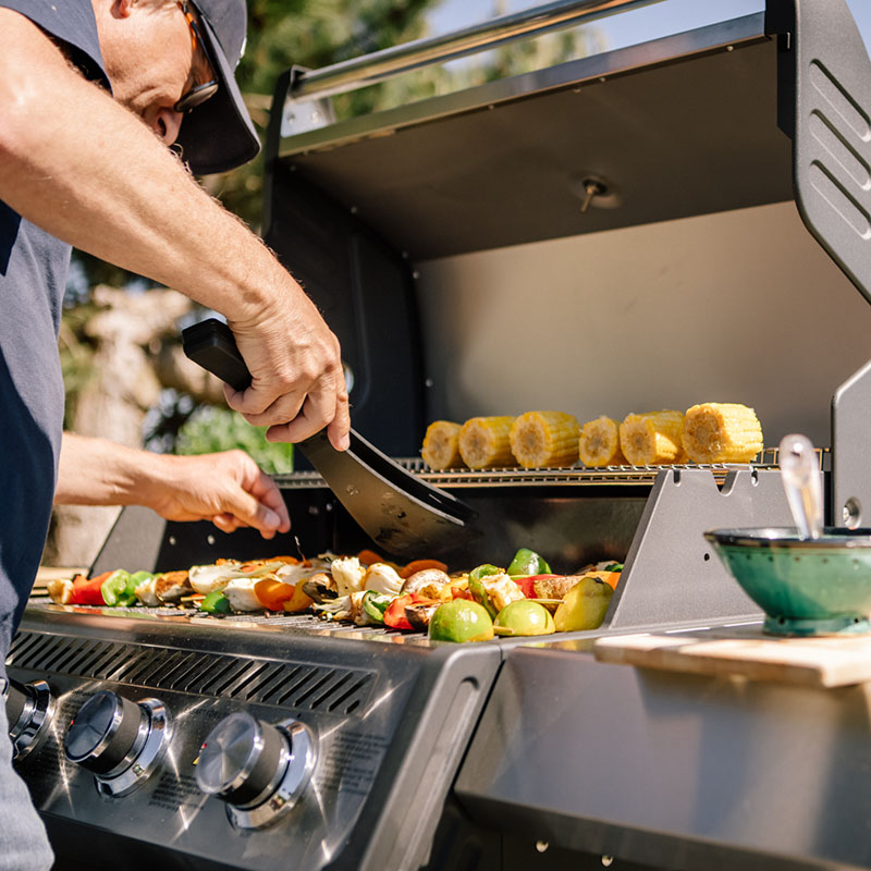 Man grillar på en Bluegaz X1 Gasolgrill med havet i bakgrunden