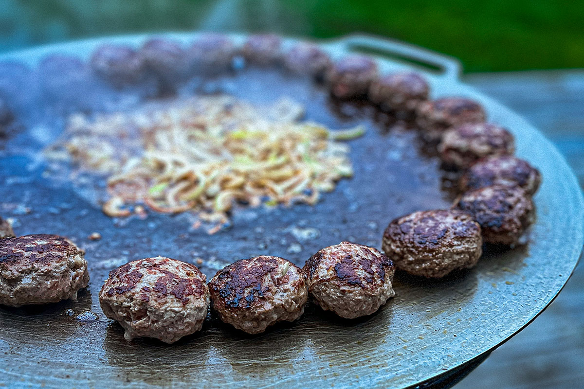 Bluegaz Timsfors Stekhäll 70 cm med pannbiffar i cirkel och lök i mitten från sidan