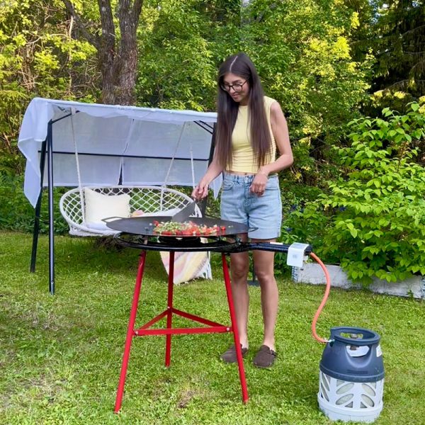 Kvinna med brunt lagar mat på Bluegaz Timfors Stekhäll set gasol 70 cm