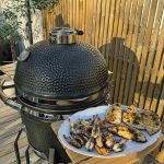 Bluegaz Kyoto Kamado Large med tallrik med färdiggrillade räkor som står på sidobord