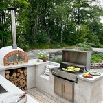 Bluegaz Z Inbyggnadsgrill inbyggd i stekunutekök med pizzaugn med spetskål som grillas