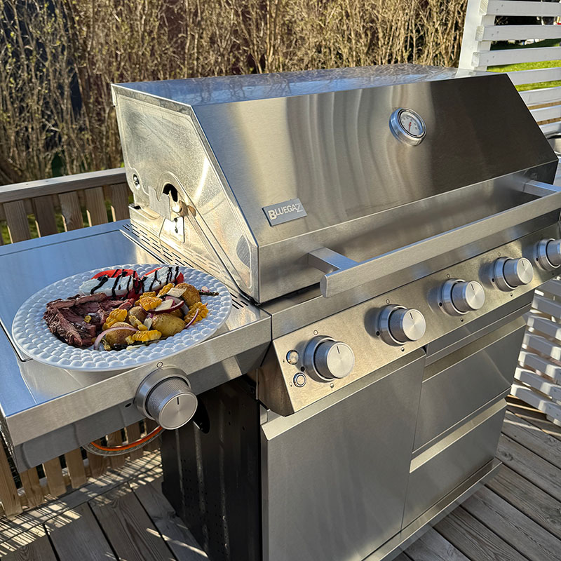 Bluegaz Z501 Gasolgrill Rostfri sedd från vänster sida med tallrik på sidobord