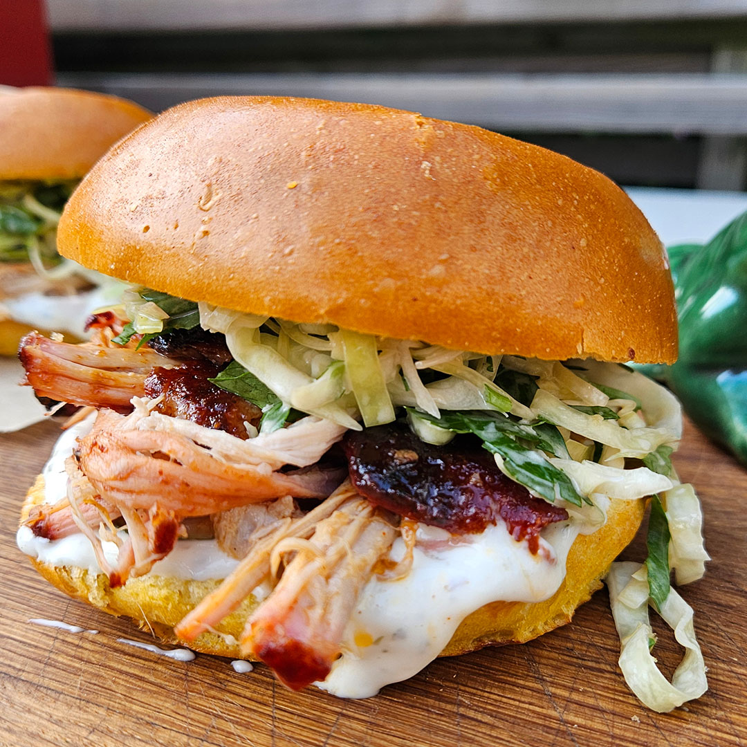 Rökt pork belly sandwich med vitlökssås, picklad gurka, picklad lök och coleslaw i briochebröd