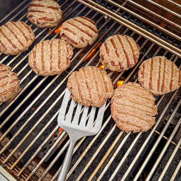 Bluegaz Elite Grillspade ligger under burgare