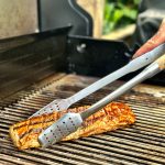 Bluegaz Elite Grilltång greppar köttbit på grill
