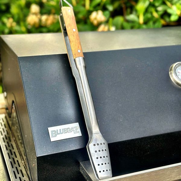 Bluegaz Elite Grilltång ligger på grillhuv