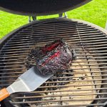 Bluegaz Elite stekspade ligger på kamadogrill under grillad köttbit