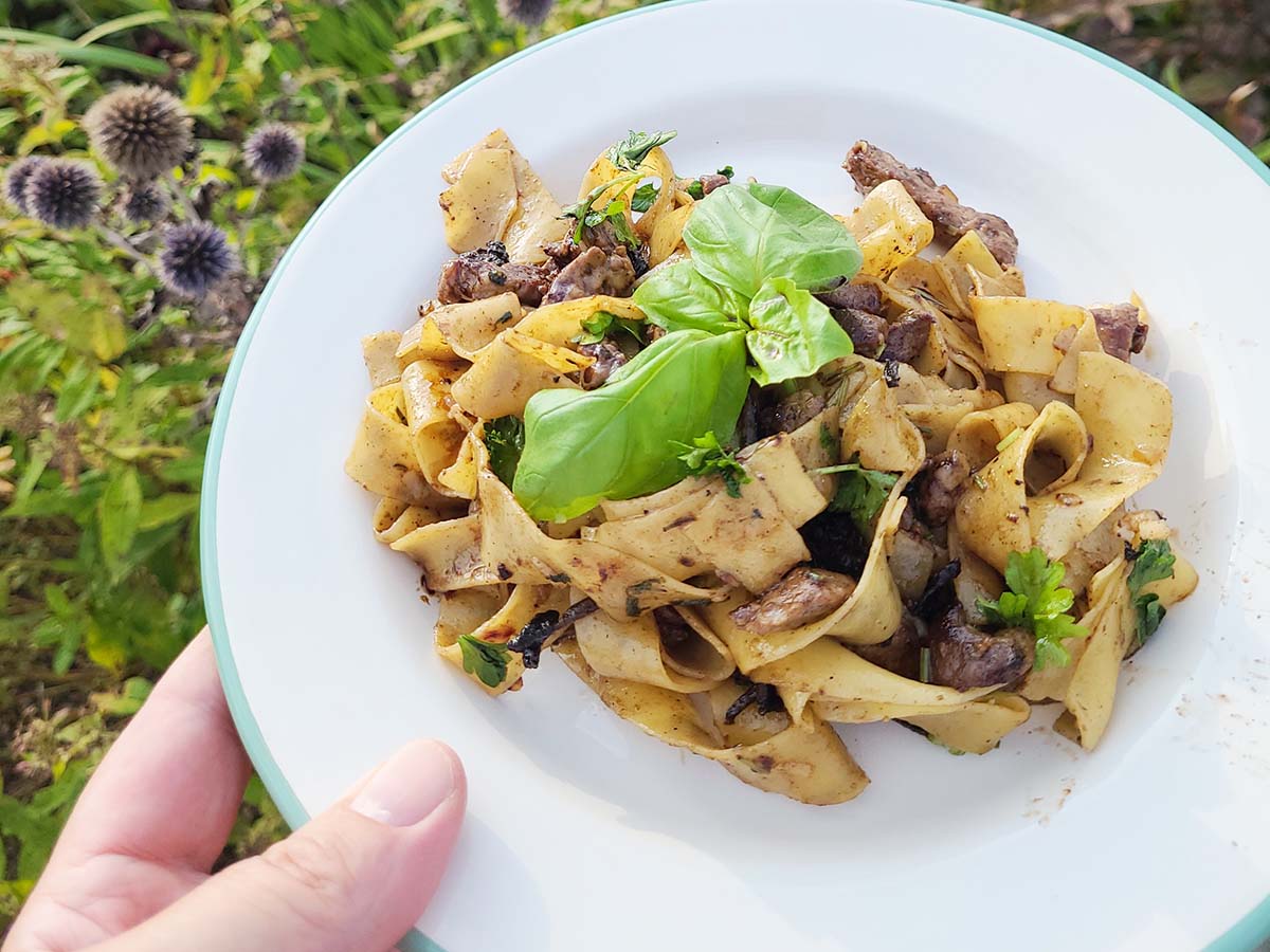 Håller i vit tallrik med oxfilépasta