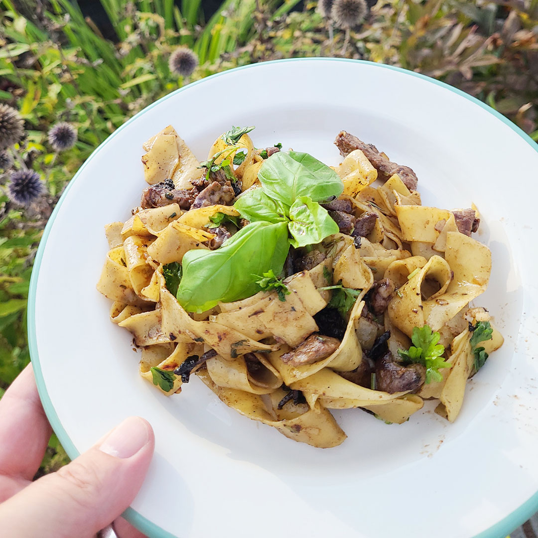 Håller i vit tallrik med oxfilépasta