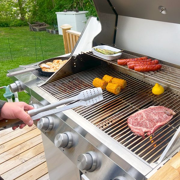 Håller i Bluegaz Elite Grilltång framför Z501 gasolgrill