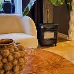 Bluegaz Kalahari Mini Gasolkamin står i vardagsrum bredvid vit soffa