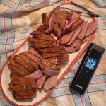 Bluegaz Trådlös Grilltermometer med 2 sonder ligger bredvid tallrik med grillad anka