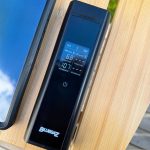 Bluegaz Trådlös Grilltermometer med 2 sonder ligger på träbord bredvid mobiltelefon