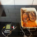 Bluegaz Trådlös grilltermometer med 4 sonder ligger vid sidan om ugnsform med vildsvinsinnanlår