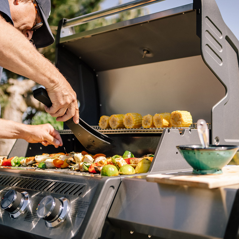 Man grillar grillspett på Bluegaz X1 Gasolgrill