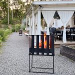 Bluegaz Bars Eldkorg står på grusmark med brinnande lågor