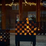 Bluegaz Chess Eldkorg med lågor och ljusslingor i bakgrunden
