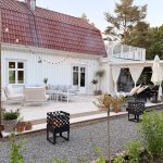 Två stycken Bluegaz Chess Eldkorgar står på grusmark framför trädäck och brinner