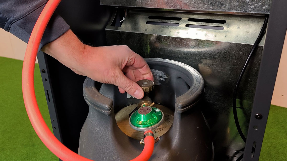Man vrider ventil på gasolflaska