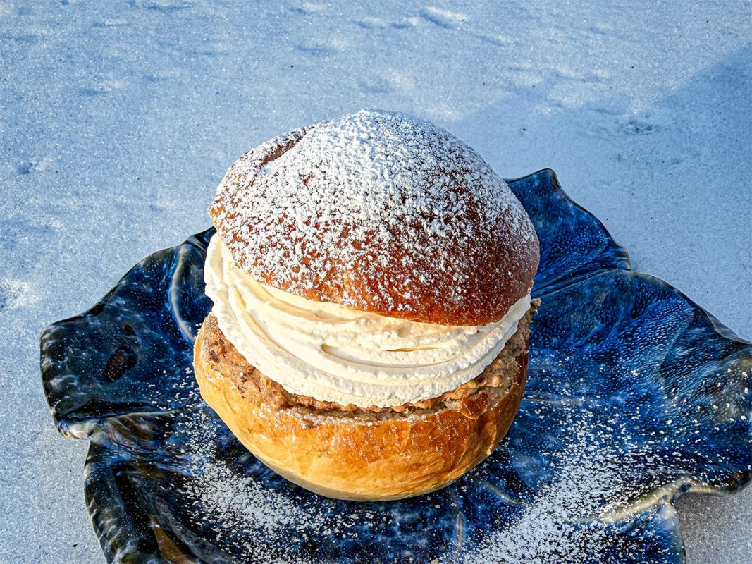 Grillad semla på blå tallrik med snön i bakgrunden
