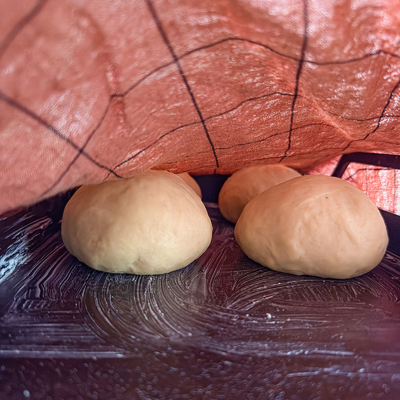 Vetebullar ligger på smörat stekbord under handduk