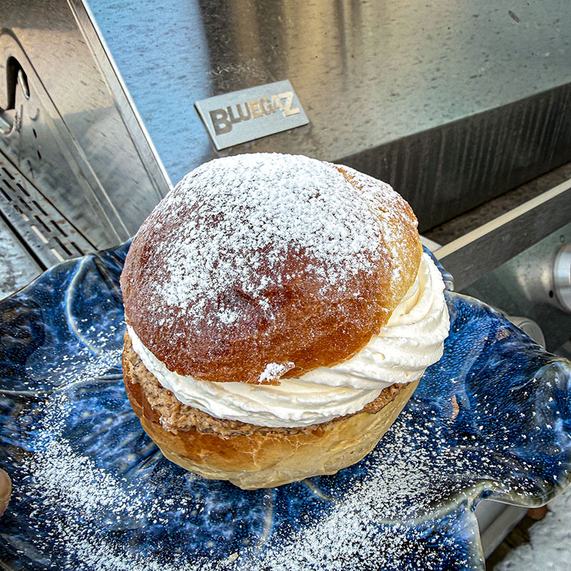 Grillad semla på blå tallrik framför Bluegaz Z501 Gasolgrill
