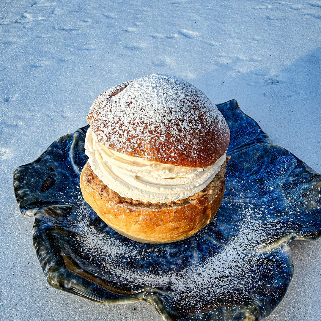 Grillad semla på blå tallrik med snön i bakgrunden