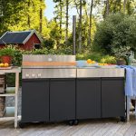 Bluegaz Z Gasolgrill med Z Sidomodul på trädäck med grönska och röd stuga i bakgrunden